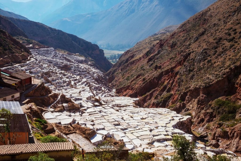 Vista panorámica de las miles de pozas de sal incas de Maras, que forman terrazas blancas y rosadas en la ladera del Valle Sagrado.