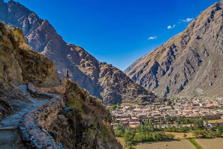 Vista parcial del histórico pueblo de Ollantaytambo, mostrando sus calles incas originales, los muros de piedra y los canales de agua que recorren la base de las casas.